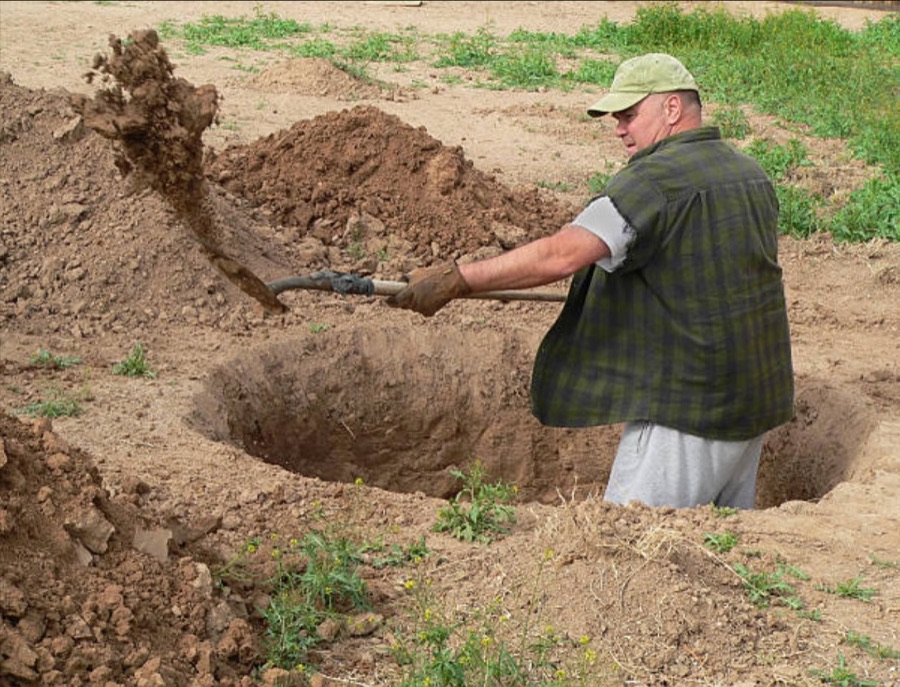 Mann gräbt mit Schaufel
